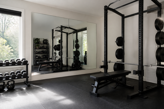 Wall-mounted gym mirrors installed with safe clearance from a power rack in a home gym